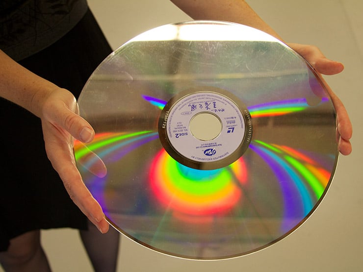 Una mujer sostiene un antiguo disco de LaserDisc.