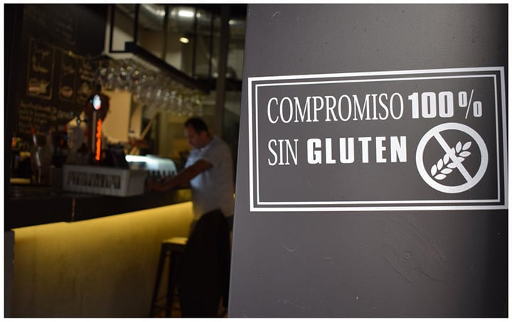 Letrero que reza “Compromiso 100% sin gluten” situado en una pared del restaurante Caroba.