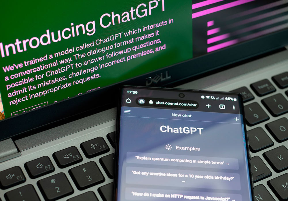 Un móvil y una pantalla de ordenador muestran la página de inicio de la web de chat.gpt.