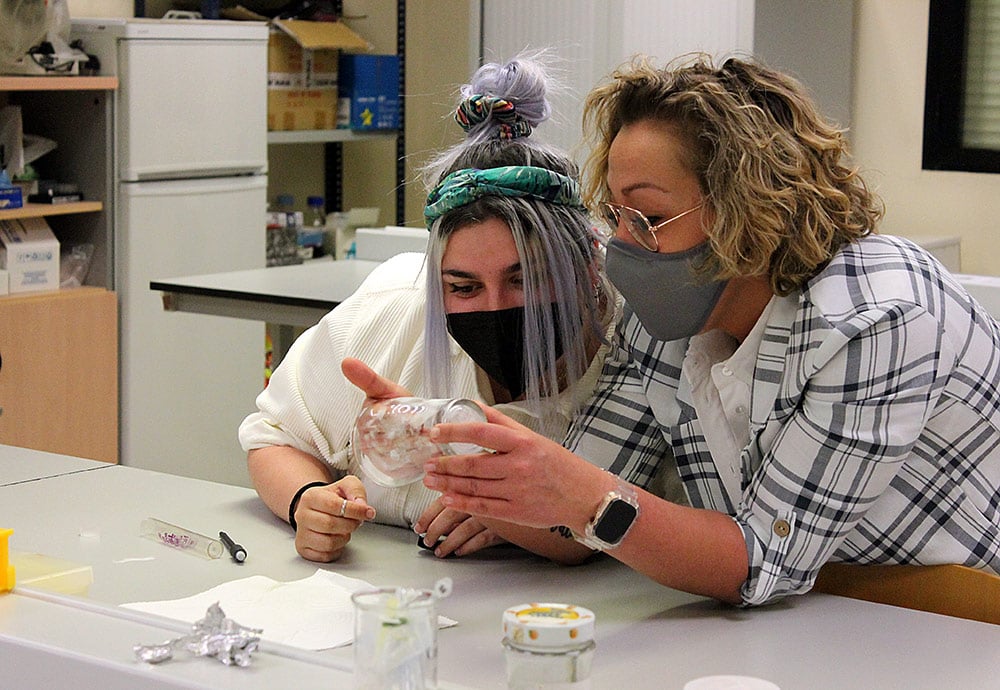Una profesora del grado en Criminología de la UEMC examina las huellas de un vaso bajo la atenta mirada de una de sus estudiantes.