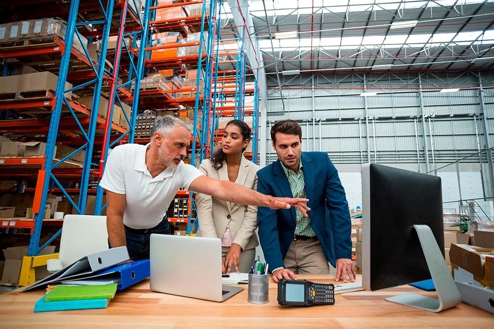 Equipo de ingeniería industrial planificando logística en almacén
