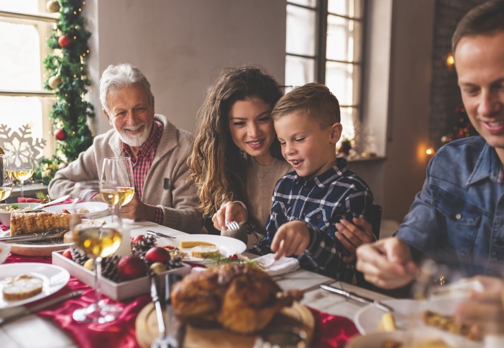 Abuelo, madre, padre e hijo cenando el día de Navidad