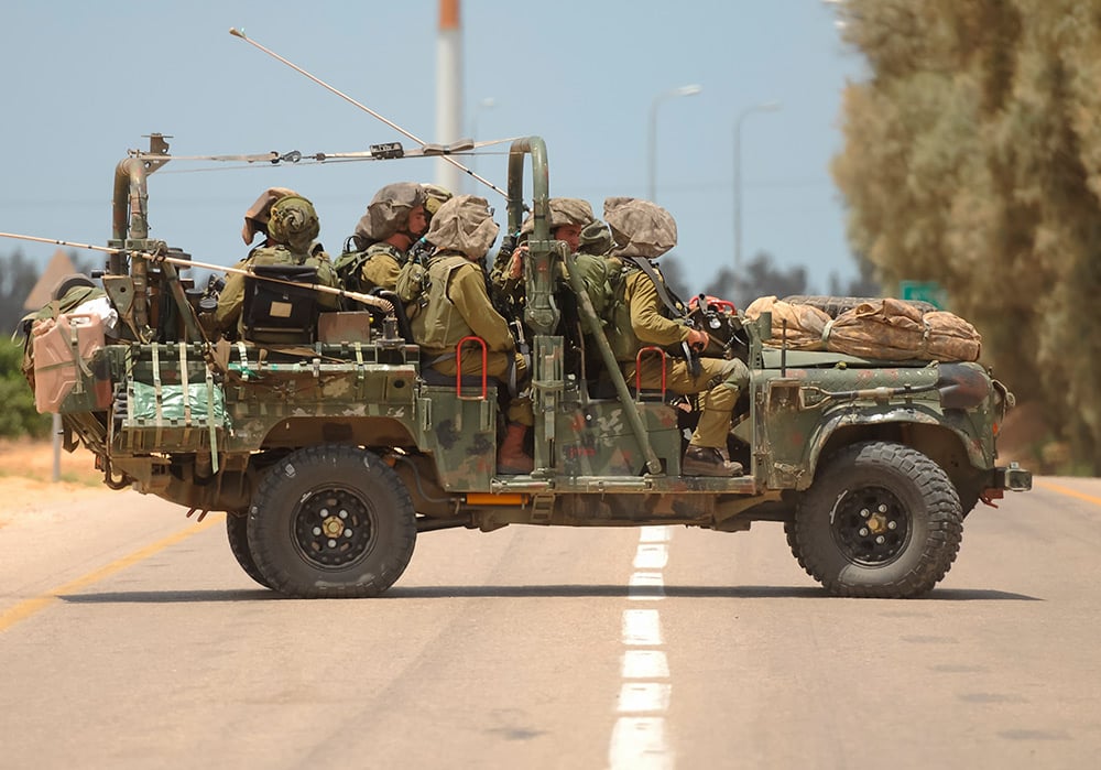 Vehículo ligero con soldados israelíes junto a la frontera de Gaza durante un conflicto.