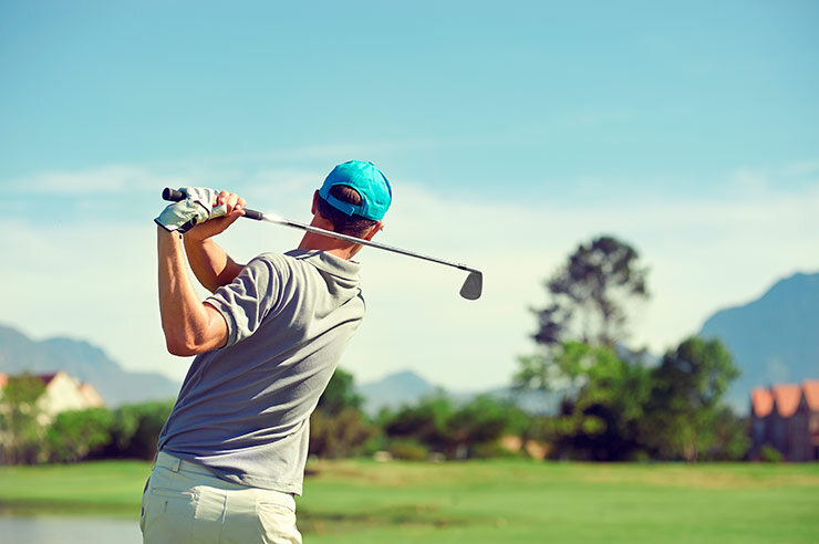 Golfista golpeando un tiro de golf con un palo en el campo durante las vacaciones de verano.