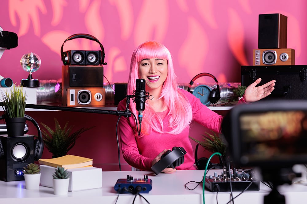 Influencer de pelo rosa habla a la cámara durante la grabación de un vídeo.