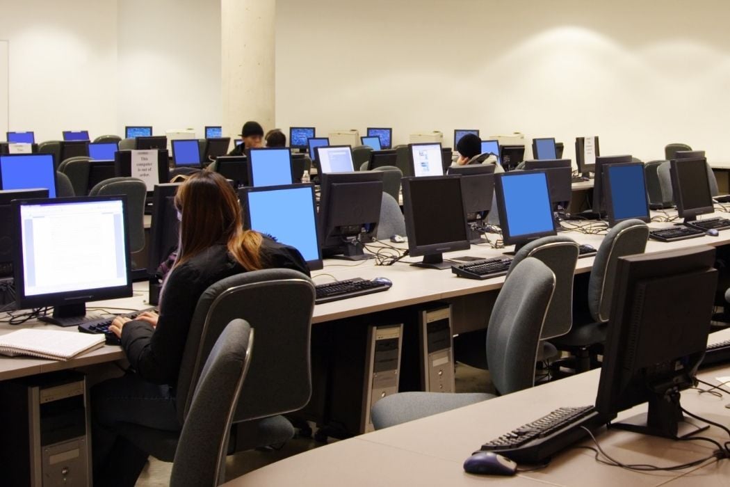 studiantes trabajando en un aula de informática vinculada al aprendizaje de tecnología y ciberseguridad
