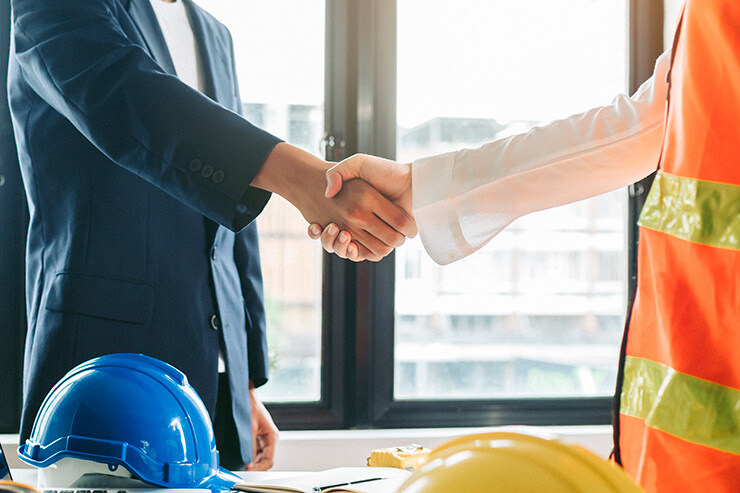 Un ingeniero de ventas estrecha la mano a un cliente.