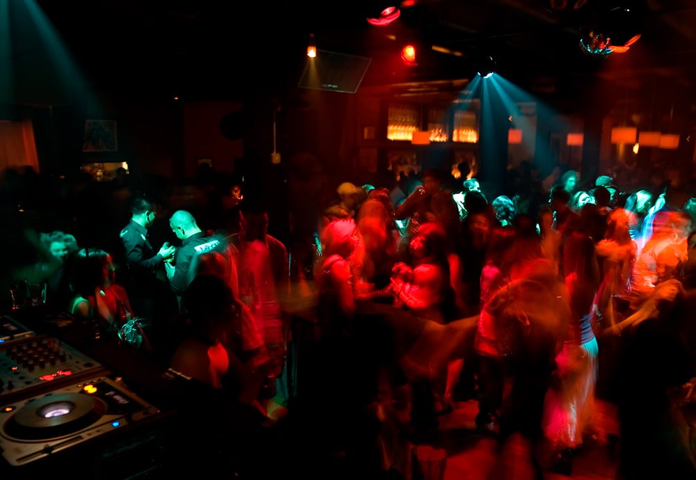 Interior de discoteca con gente bailando.