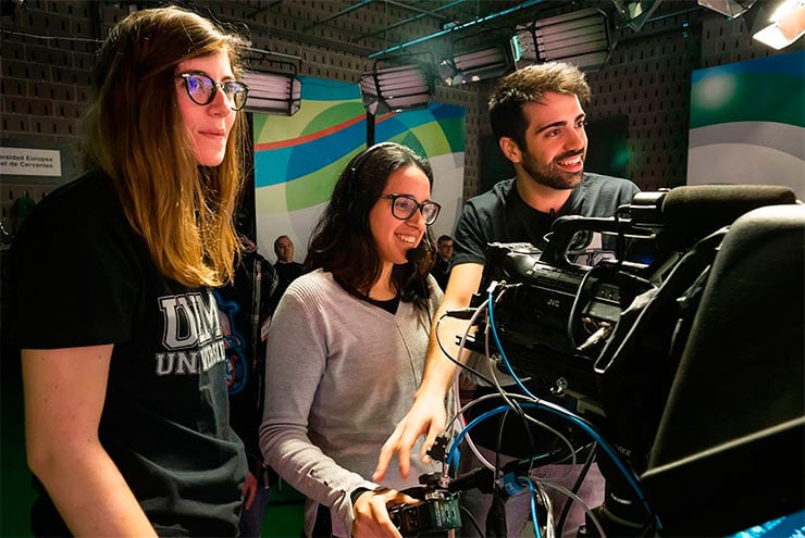 Dos estudiantes de la UEMC enseñan a una joven preuniversitaria cómo funciona una cámara de televisión en el plató de Cine de la UEMC.