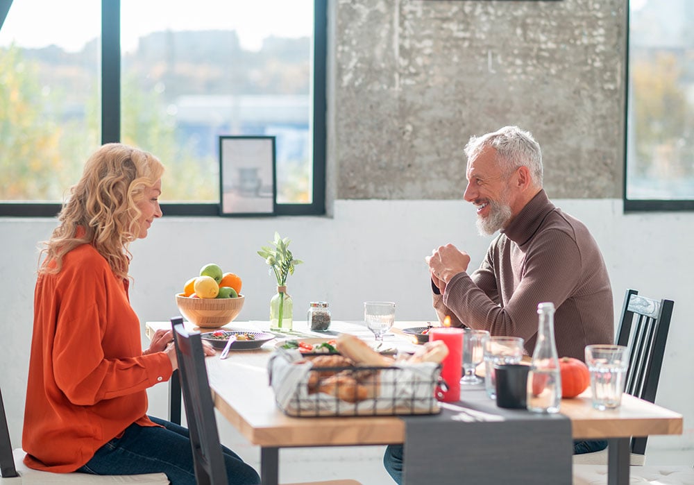 Una imagen muestra una pareja de personas mayores comiendo en un restaurante. 