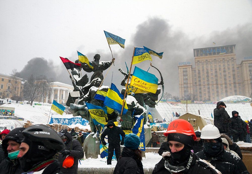 Imágenes de las  protestas de Maidán a finales de 2013 con manifestantes equipados con casco y banderas de Ucrania.