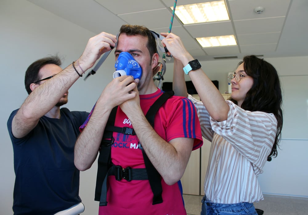 Susana López, junto a Alejandro Santos, colocan una mascarilla de oxígeno a un paciente antes de realizar una prueba de ejercicio.