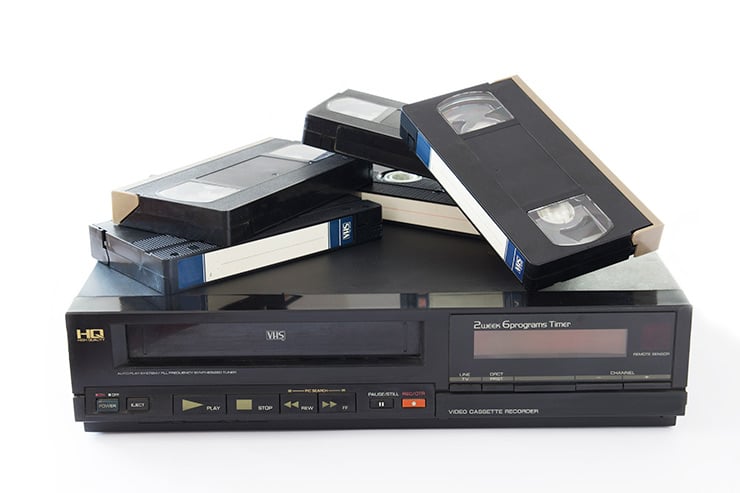 Antiguo vídeo VHS con algunas cintas de vídeo colocadas encima.