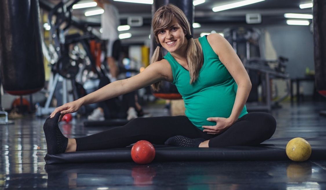 Mujer embarazada realizando ejercicio físico adaptado en un gimnasio