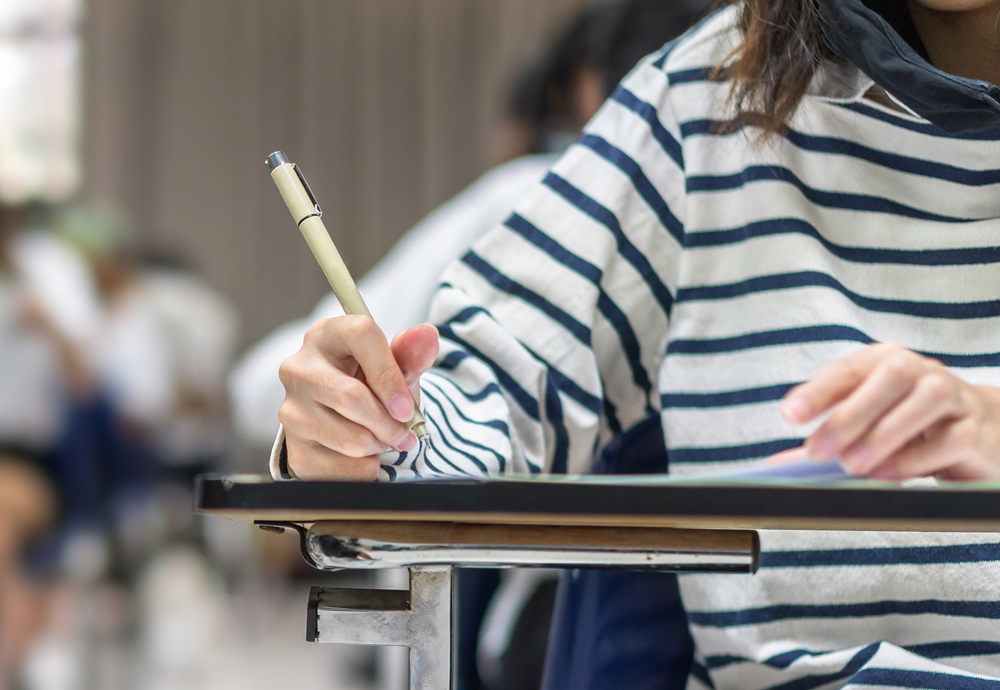 Una imagen que muestra a una alumna haciendo un examen. 