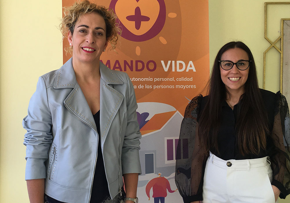 Marta Lorenzo e Inmacula González posan delante de un rolla up en la oficinas de Sumando Vida, su nuevo proyecto empresarial