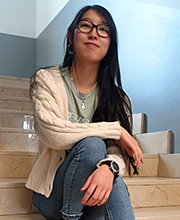 La estudiante de la UEMC sentada en una de las escaleras de la universidad.